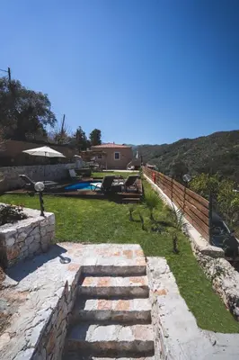 a backyard with a stone path and a swimming pool at Ampelos Cretan Villa - Private Pool & Heated Ozone Jacuzzi in Gerolakkos