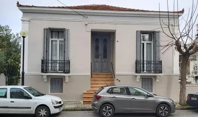 two cars parked in front of a white house at Philoxenia Residence Chania City Centre in Chania Town