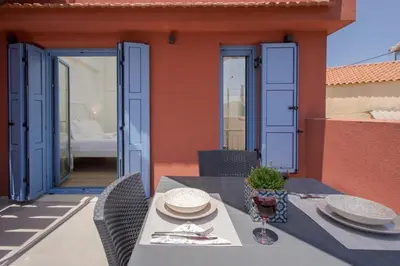 a patio with a table and chairs on a house at Mouse House with Sea View and Mini Pool in Plataniás