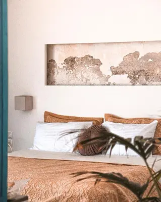 a bedroom with a bed with a painting on the wall at Esperanto seafront studio in Agia Marina Nea Kydonias