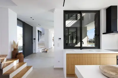 a kitchen with white walls and a sink and wooden counters at Villa al Sur in Chania Town