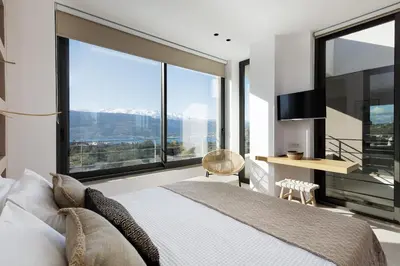 a bedroom with a bed and large windows at Villa al Sur in Chania Town