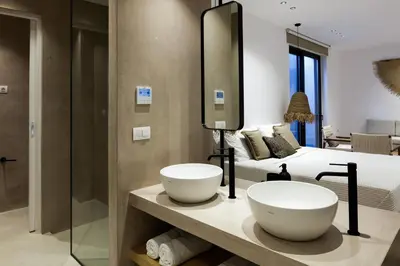 a bathroom with two sinks in front of a bed at Villa al Sur in Chania Town