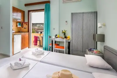 a room with a large white bed in a kitchen at Louladakis Apartments in Kolymvari