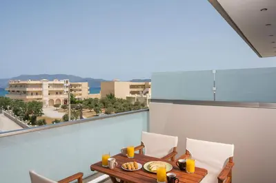 a table and chairs on a balcony with a view at INDIGO BLUE Seaside Deluxe Apartments in Kissamos