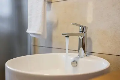 a white sink with a faucet in a bathroom at INDIGO BLUE Seaside Deluxe Apartments in Kissamos