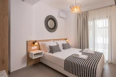 a bedroom with a large bed with black and white pillows at INDIGO BLUE Seaside Deluxe Apartments in Kissamos