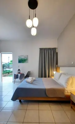a bedroom with a large bed and a table at Stelios Studios Sougia in Sougia
