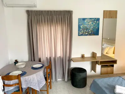 a living room with a table and a dining room at Stelios Studios Sougia in Sougia