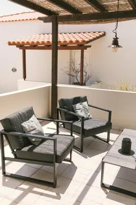 two chairs and a table on a patio at Grey House in Chorafakia