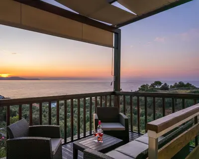 a patio with a table and chairs with a view of the ocean at Dreamy View Inn in Chania Town