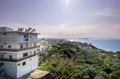 a building on a hill next to the ocean at Dreamy View Inn in Chania Town