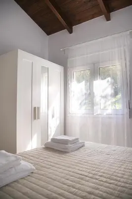 a white bedroom with a bed and a window at jAne's house in Ravdhoúkha