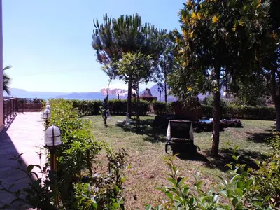 a park with a chair and trees and a person on a bike at Aphrodite View in Korakiaí