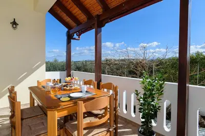 a dining table on the balcony of a house at Villa Albion in Kolymvari