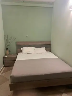 a bed in a bedroom with a white wall at Ledakis House with Jacuzzi in Frangokastello