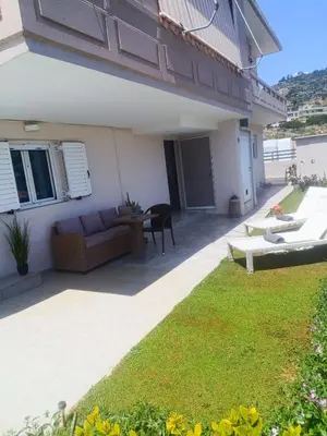 a patio with a couch and a grass yard at Sunrise Apartment 2 in Souda