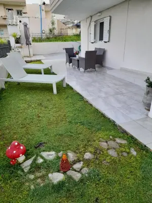 a garden with a bench and a table and chairs at Sunrise Apartment 2 in Souda