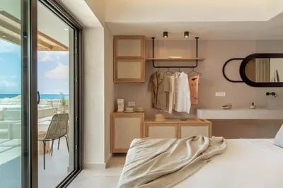 a bedroom with a bed and a view of the ocean at Esperanto Seafront suites in Agia Marina Nea Kydonias