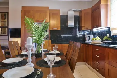 a kitchen with a table with plates and wine glasses at Villa Milon by PosarelliVillas in Skinés