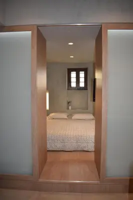 a view of a bedroom with a bed through a mirror at Saxon's Apartment in Chania Town