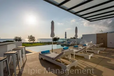 a view of the swimming pool and the beach from a house at Seafront VILLA PELAGIA SUPERB New listing in Chania Town