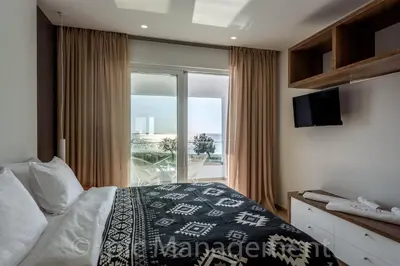 a bedroom with a bed and a large window at Seafront VILLA PELAGIA SUPERB New listing in Chania Town