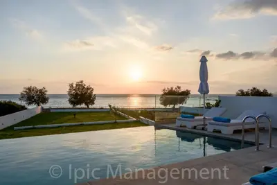 a villa with a swimming pool at sunset at Seafront VILLA PELAGIA SUPERB New listing in Chania Town