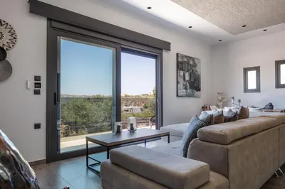 a living room with a couch and a table at ÉTHAFOS Luxury Apartment in Tsikalariá