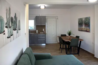 a living room and kitchen with a table and chairs at THALIA APARTMENTS CHANlA in Chania Town