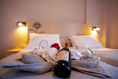 a hotel room with towels and a bottle of wine on a bed at Vakakis Family Luxury Studios in Palaiochóra