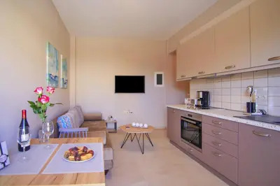 a kitchen and living room with a couch and a table at Vakakis Family Luxury Studios in Palaiochóra