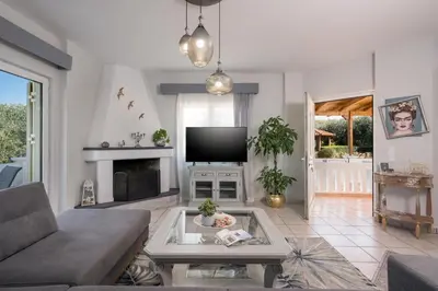 a living room with a couch and a tv at Casa de philippe with unique Seaview 2' from beach in Ayiá