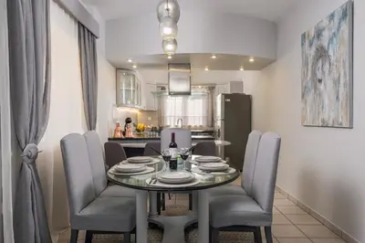 a dining room with a table and chairs and a kitchen at Casa de philippe with unique Seaview 2' from beach in Ayiá