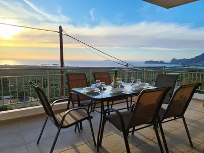 a table and chairs on a balcony with a view at New Villa Kalimera, view to Falasarna beach in Plátanos