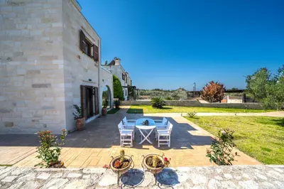a patio with a table and chairs next to a building at FOS residence - ΦΩΣ ,luxury villa in Chania Town