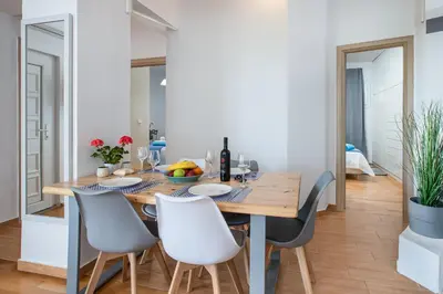 a dining room with a wooden table and chairs at DIMITRA apartment with private pool and sea view -the ground floor of a two storey building in Daratso