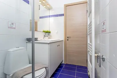 a bathroom with a toilet and a sink at DIMITRA apartment with private pool and sea view -the ground floor of a two storey building in Daratso
