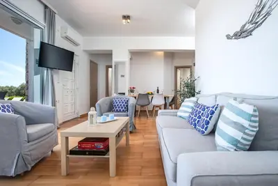 a living room with two couches and a table at DIMITRA apartment with private pool and sea view -the ground floor of a two storey building in Daratso