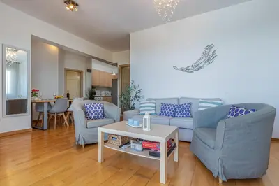 a living room with two blue chairs and a table at DIMITRA apartment with private pool and sea view -the ground floor of a two storey building in Daratso