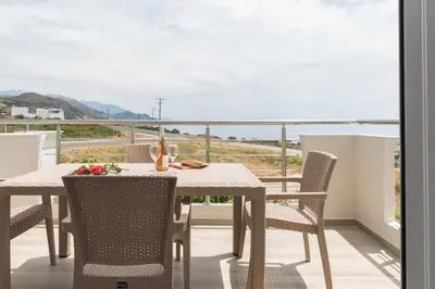 a table and chairs on a balcony with a view at Allview apartments in Palaiochóra