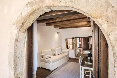 an archway in a living room with a chair and a table at Sclopa The Laography Project in Kolymvari