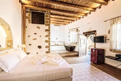 a bedroom with a bed and a tv in a room at Sclopa The Laography Project in Kolymvari