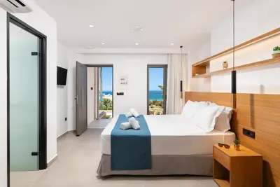 a bedroom with a bed with a view of the ocean at Diamond Star Hotel in Falasarna