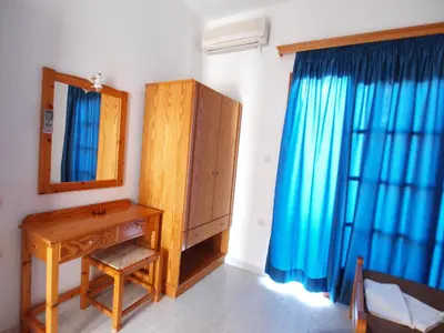 a bathroom with a wooden dresser and a mirror at Irini Apartments in Plataniás