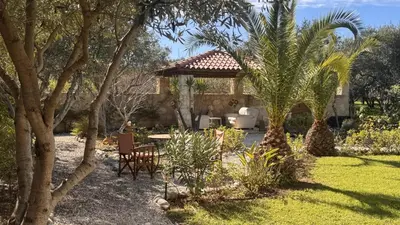 a garden with a house with a table and chairs at World Villa in Tavronitis