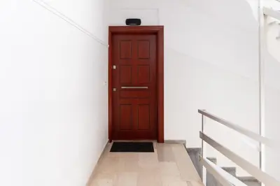 a brown door in a white room with stairs at Dream Casa by the Sea by 8essentially in Chania Town