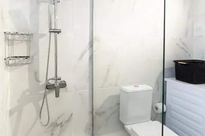 a white bathroom with a shower and a toilet at Dream Casa by the Sea by 8essentially in Chania Town
