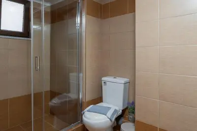 a bathroom with a toilet and a glass shower at Mariviky design apartment in Chania Town