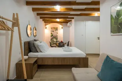 a bedroom with a large bed and a couch at Mariviky design apartment in Chania Town